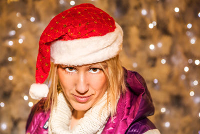 Portrait of smiling mature woman wearing santa hat during christmas