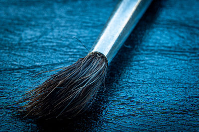 High angle view of paintbrushes on blue table