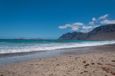 Scenic view of beach against blue sky