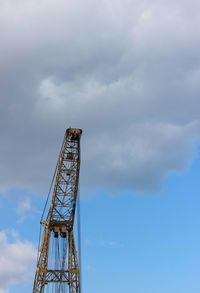 Low angle view of crane against sky