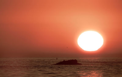 Scenic view of sea against orange sky