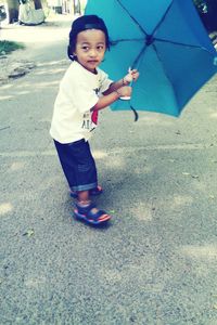 Portrait of happy boy standing on road