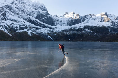 Man ice-skating on frozen lake