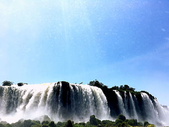 Scenic view of waterfall against sky