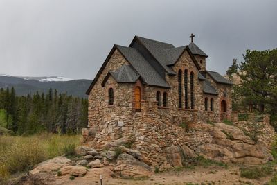 House by tree against sky