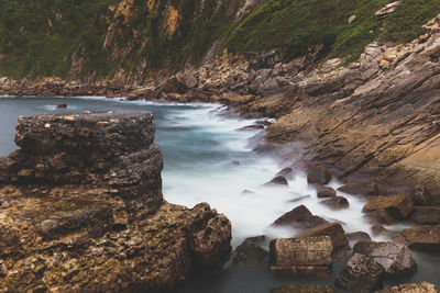 Rock formations by sea against sky