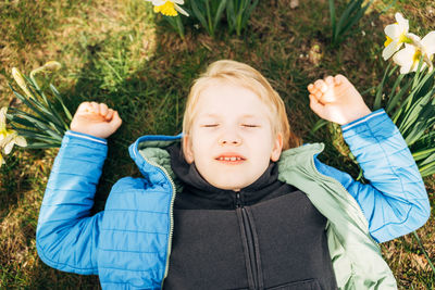 Portrait of young woman standing against plants