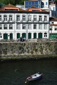 Boats in river by buildings in city