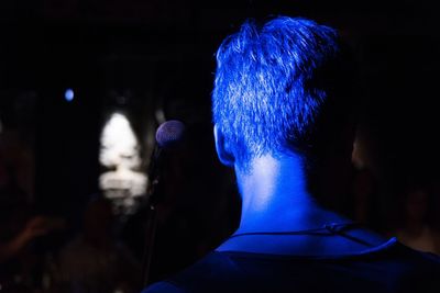 Rear view of woman in illuminated nightclub