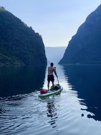 People on boat in sea against sky