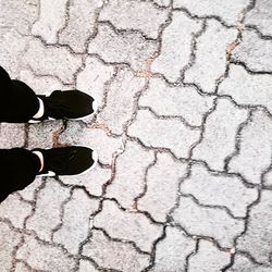 Low section of person standing on tiled floor