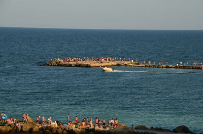 People on beach against clear sky