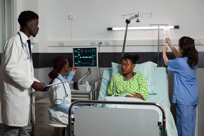 Doctors and nurse examining patient in clinic