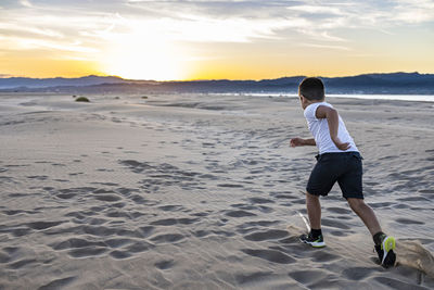 Full length of boy running on beach