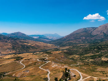 High angle view of mountain road against blue sky