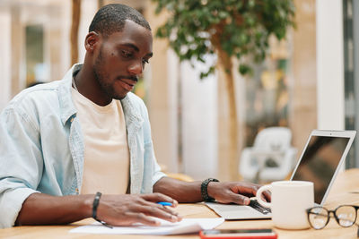 Young man using laptop at office