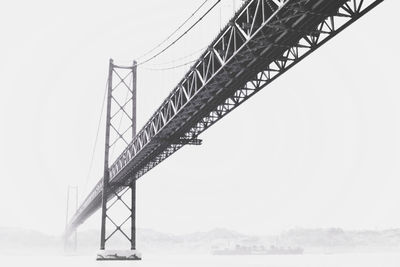 Low angle view of suspension bridge in foggy weather