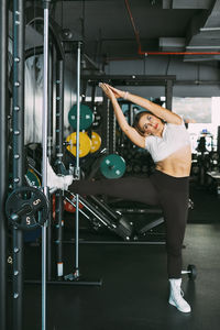 An active girl does stretching exercises after a workout in the gym. sports, fitness, healthy body 