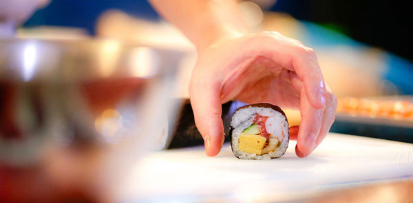 Cropped hand of woman holding toy on table