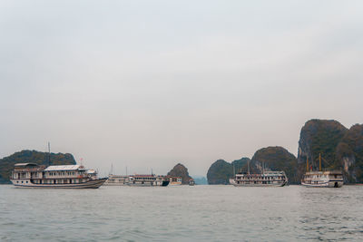 Boats on sea by buildings against sky