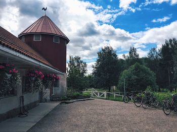 Walkway amidst trees against sky