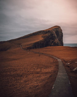 Road leading towards mountain against sky