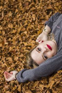 Portrait of woman lying down on ground during autumn