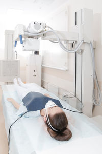 High angle view of woman lying on bed for x ray