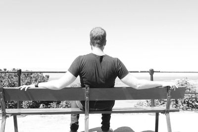 Rear view of man standing on bench