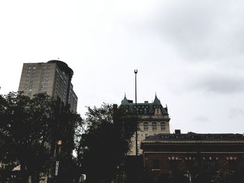 Low angle view of buildings against cloudy sky