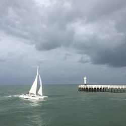 Sailboat sailing on sea against sky