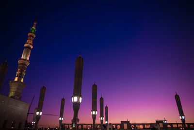 Low angle view of illuminated buildings against blue sky