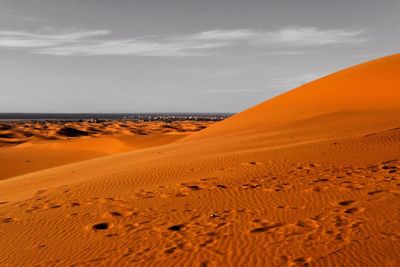 Sand dunes in desert against sky