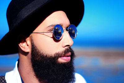 Close-up of young man wearing sunglasses and hat