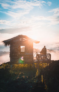 Built structure on field against sky during sunset