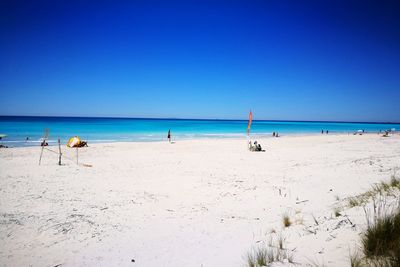 Scenic view of beach against clear blue sky