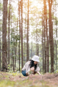 Woman on tree trunk in forest