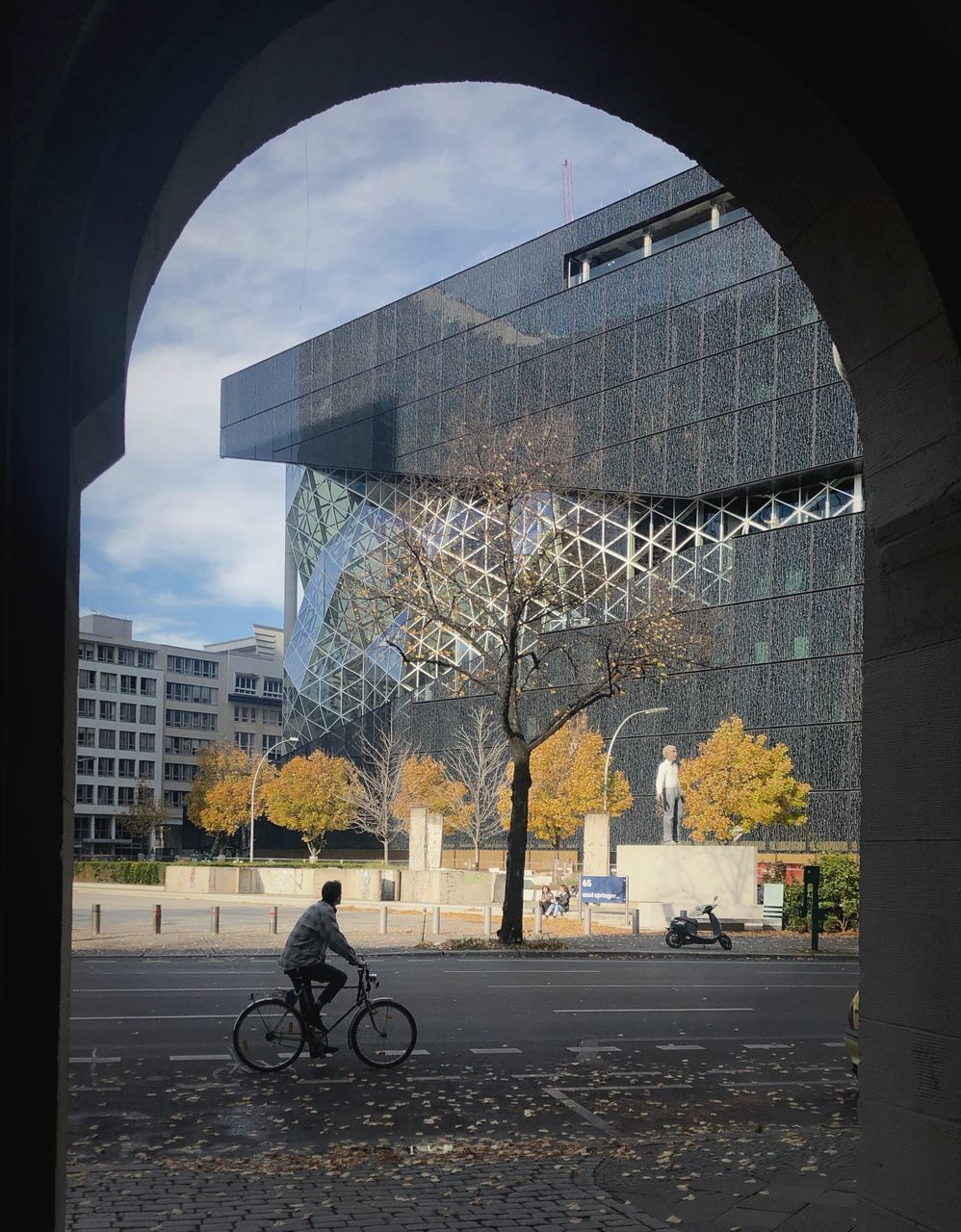 MAN RIDING BICYCLE ON STREET AGAINST BUILDINGS