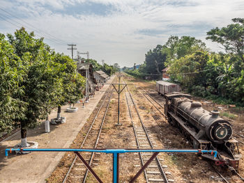 Railroad tracks amidst trees against sky