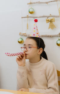 Portrait of a beautiful girl blowing a trumpet at a birthday party.