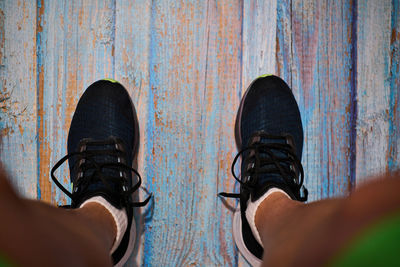 Low section of person standing on wood