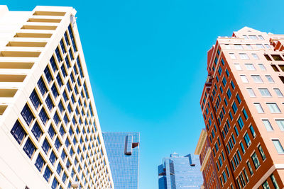 Low angle view of modern buildings against clear blue sky