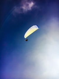 Low angle view of person paragliding in sky