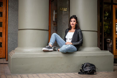 Young woman sitting on sofa at home