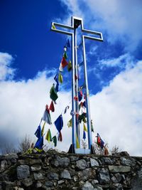 Low angle view of flags on rocks against sky