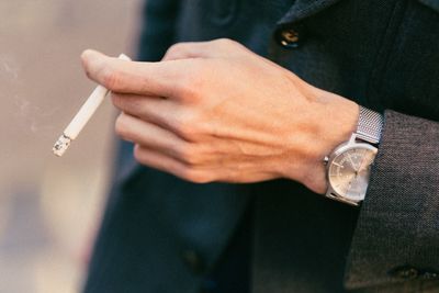 Midsection of man smoking cigarette