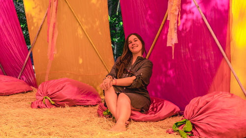 Portrait of young woman sitting on tent