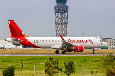 Airplane on airport runway against sky