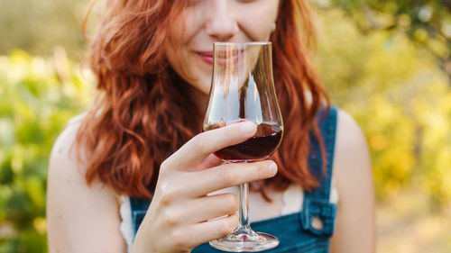 Woman with glass of red wine in the vineyard