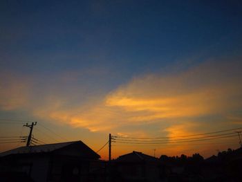 Low angle view of silhouette communications tower against sky during sunset